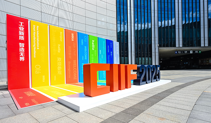 Colorful CIIF 2025 display with multilingual greetings, set outside a modern building.